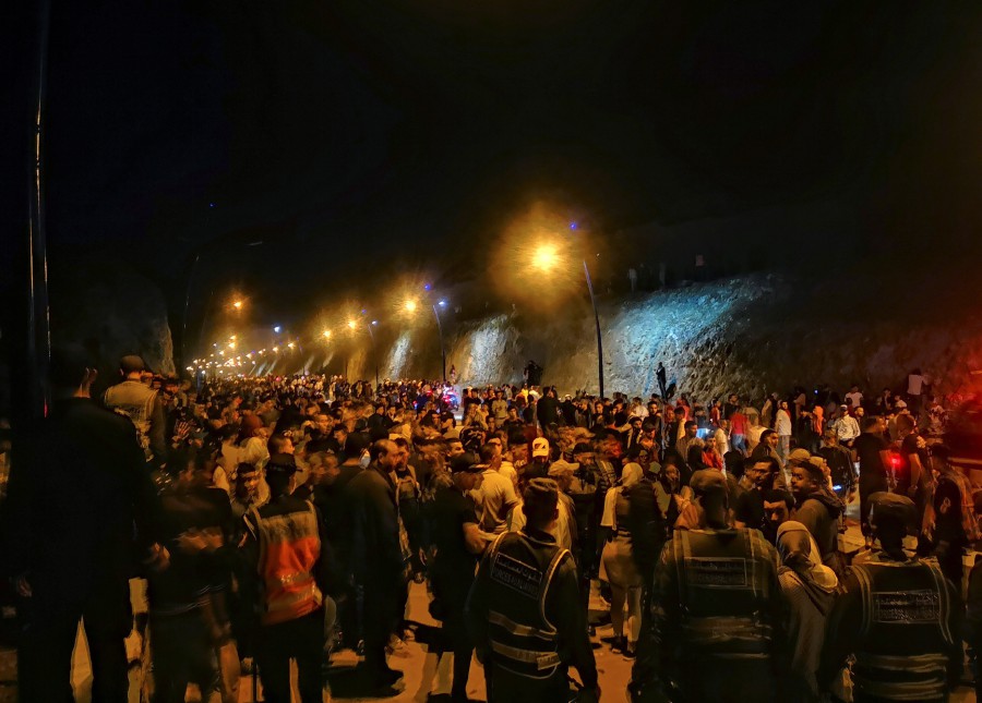 Hundreds of young Moroccans wait to cross the border with Spain in the town of Castillejos, also known as Fnideq. -EPA pic