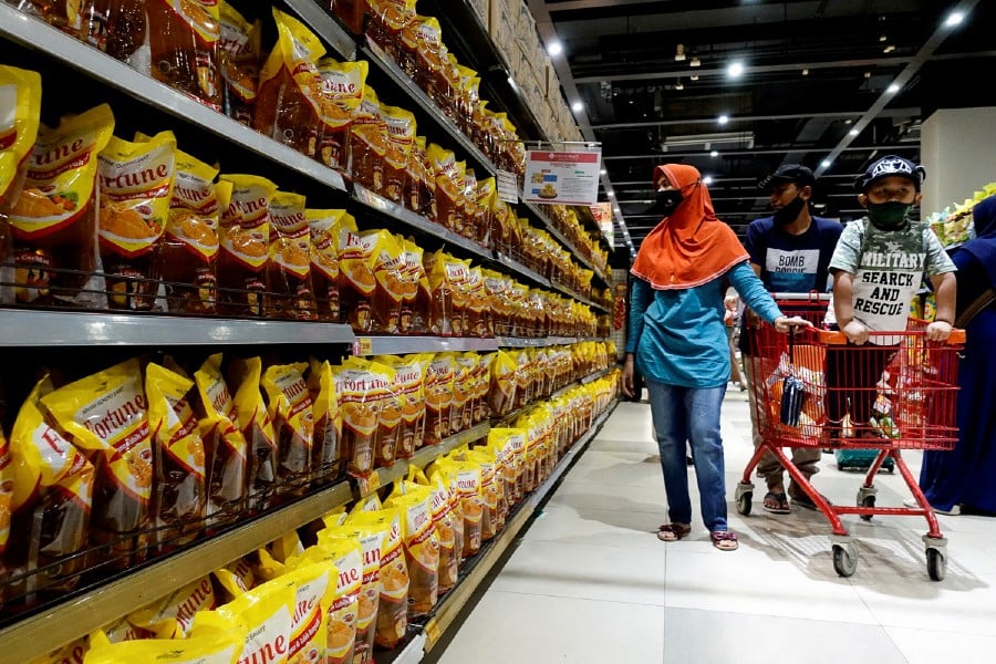 People shop for cooking oil made from oil palms at a supermarket in Jakarta, Indonesia. - REUTERS PIC