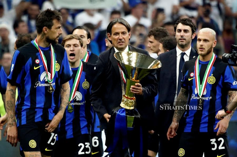 Inter Milan coach Simone Inzaghi celebrates with the trophy after winning the Serie A at the San Siro on May 19, 2024. - REUTERS PIC