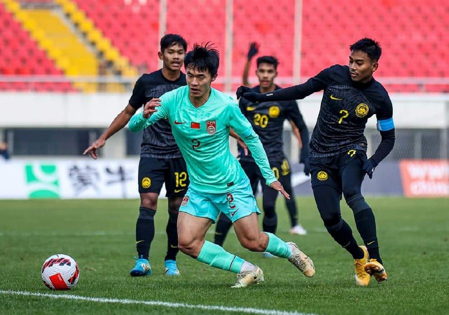 Malaysian Under-23 players (in black) in action against China. - Pic courtesy of FA of Malaysia