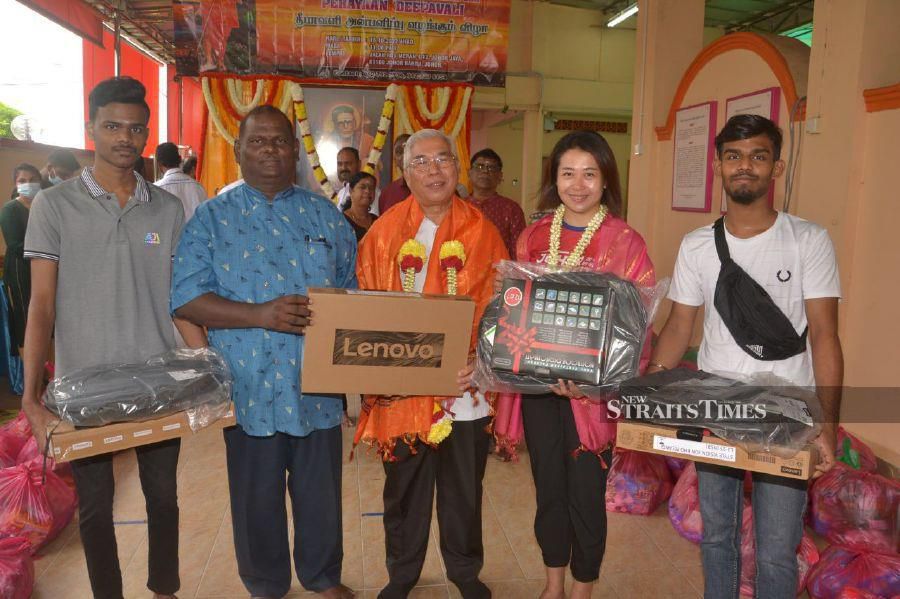 Pasir Gudang member of parliament Datuk Hassan Abdul Karim (third from left) handing over laptops to two students and a non-governmental organisation. With them are Johor Jaya assemblyman Liow Cai Tung (second from right). - Pic by Vincent D’Silva