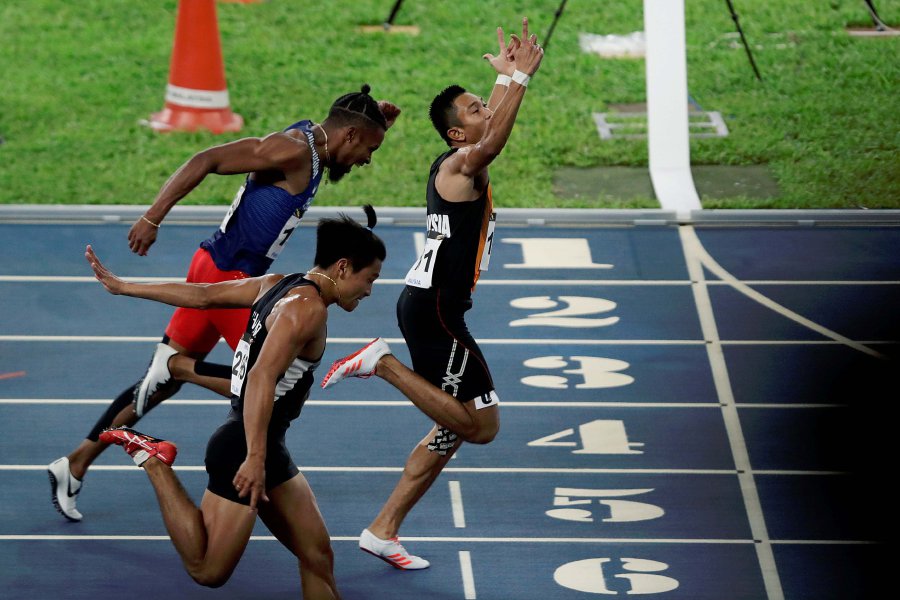 Khairul Hafiz Jantan (cente) finishes ahead of Philippines’ Eric Cray (left, in blue) and Kritsada Nasuwun during the men’s 100m final race. Pic by AIZUDDIN SAAD