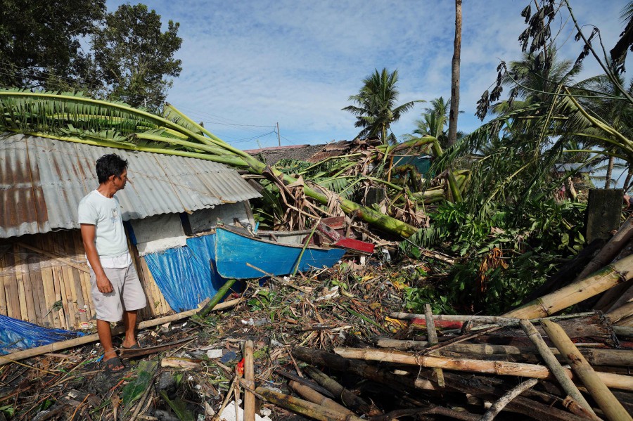A resident looks at his damaged home in the coastal town of Dulag in Leyte province on December 17, 2021, a day after Super Typhoon Rai hit. -AFP PIC 