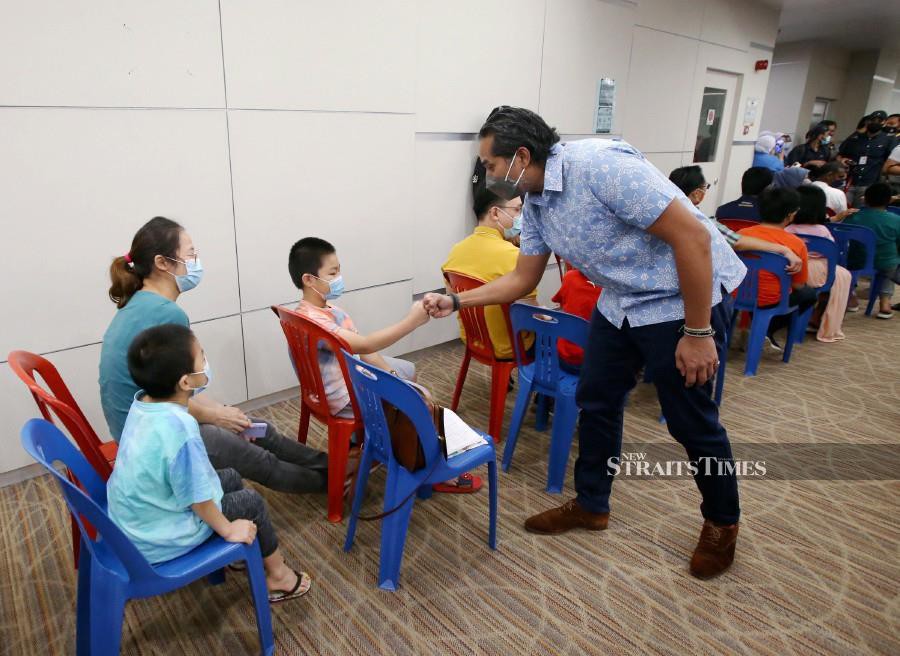 Health  Minister Khairy Jamaluddin mingles with a child, waiting to receive his Covid-19 vaccine at the launch of PICKids programme at the Tunku Azizah Hospital.  -NSTP/EIZAIRI SHAMSUDIN