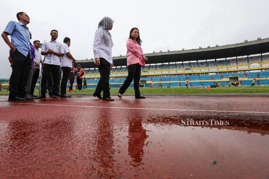 Youth and Sports Minister Hannah Yeoh (left) with Darul Makmur Stadium Corporation manager Izad Zainal Muhammad Saffian inspecting the newly laid track in Kuantan. - NSTP/LUQMAN HAKIM ZUBIR
