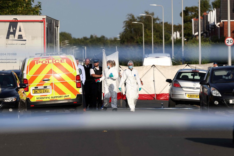 Police officers and forensic personnel put up a fence on Hart Street in Southport, northwest England, following a knife attack. - AFP PIC