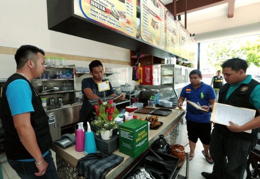 Authorities from the Domestic Trade, Cooperatives, and Consumerism Ministry and the Customs Department doing checks at restaurant in Kota Kinabalu recently, in light of the GST implementation.