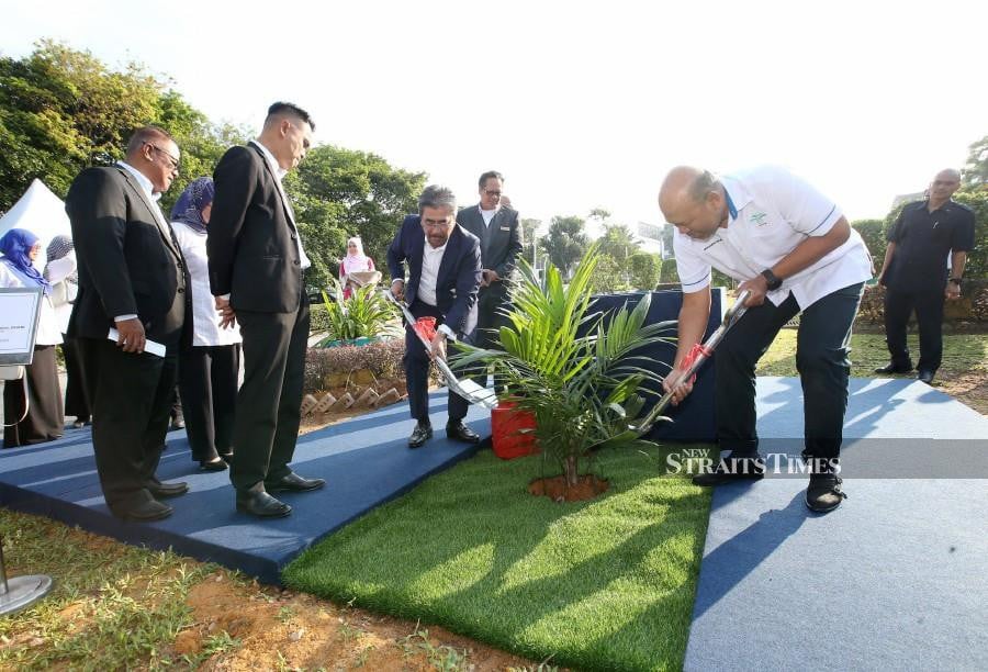 Plantations and Commodities Minister Datuk Seri Johari Abdul Ghani (left) and Malaysian Palm Oil Board chairman Datuk Mohamad Helmy Othman planting an oil palm tree to commemorate the Malaysian Palm Oil Board (MPOB) Excellence Awards 2023. NSTP/EIZAIRI SHAMSUDIN