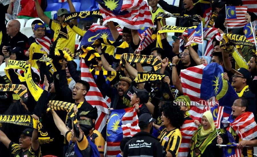 Malaysian fans cheering their team during the match against Jordan in Doha. -NSTP/HAIRUL ANUAR RAHIM