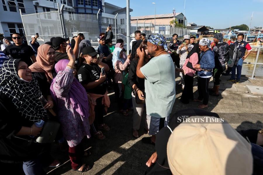 Family members hug and cry as the anglers and crew members safely returned to the MMEA jetty in Kuala Terengganu. - NSTP/GHAZALI KORI