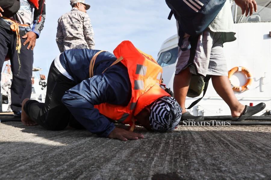 Zairi Nurudin, fells on his knees in supplication after arriving safely at the MMEA jetty in Kuala Terengganu. - NSTP/GHAZALI KORI