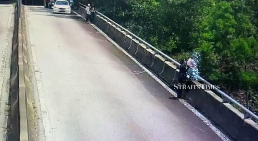 A video clip of the incident showed the girl sitting on the edge of the flyover as Maznan approached her. When he was 10m or so away from her, he stopped and looked over the edge of the flyover, then crossed to the other side. - NST/screengrab