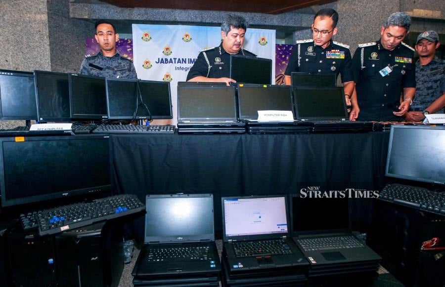 Part of the confiscation was seized in an online investment fraud scam in Cyberjaya at a press conference at the Putrajaya Immigration Headquarters. (NSTP/LUQMAN HAKIM ZUBIR)