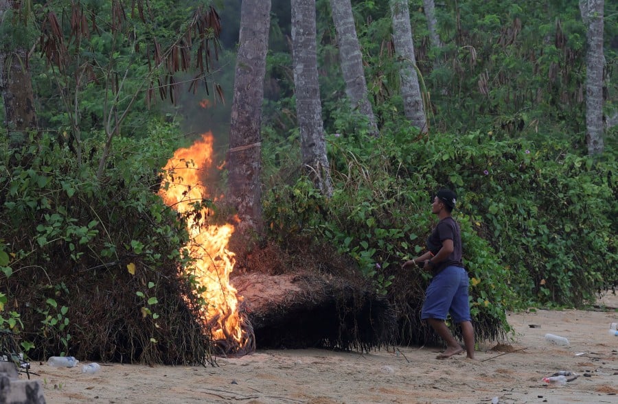 A resident of Kinarut in Papar burns rubbish in this picture taken last month. The Sabah Department of Environment is actively enforcing laws against open burning, says state Assistant Tourism, Culture and Environment Minister Datuk Joniston Bangkuai. Bernama file pic