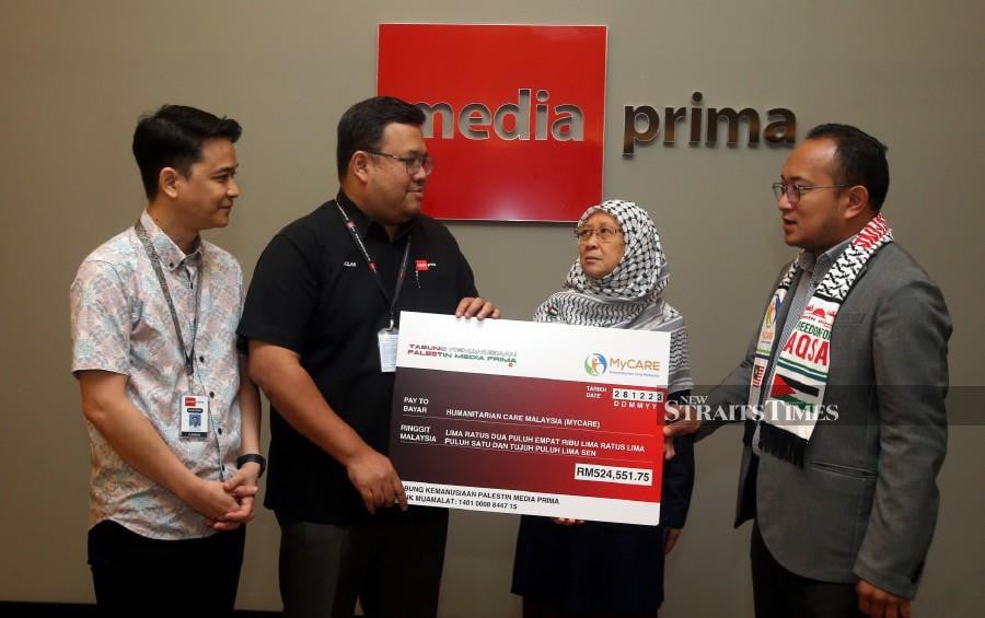 Media Prima Group Corporate Communications and the Group Chairman’s Office, Azlan Abdul Aziz (2nd-left) presenting a mock cheque to MyCare’s Board of Trustees, Dr Fauziah Mohd Hasan (2nd-right) during the ceremony in Kuala Lumpur. -NSTP/HAIRUL ANUAR RAHIM