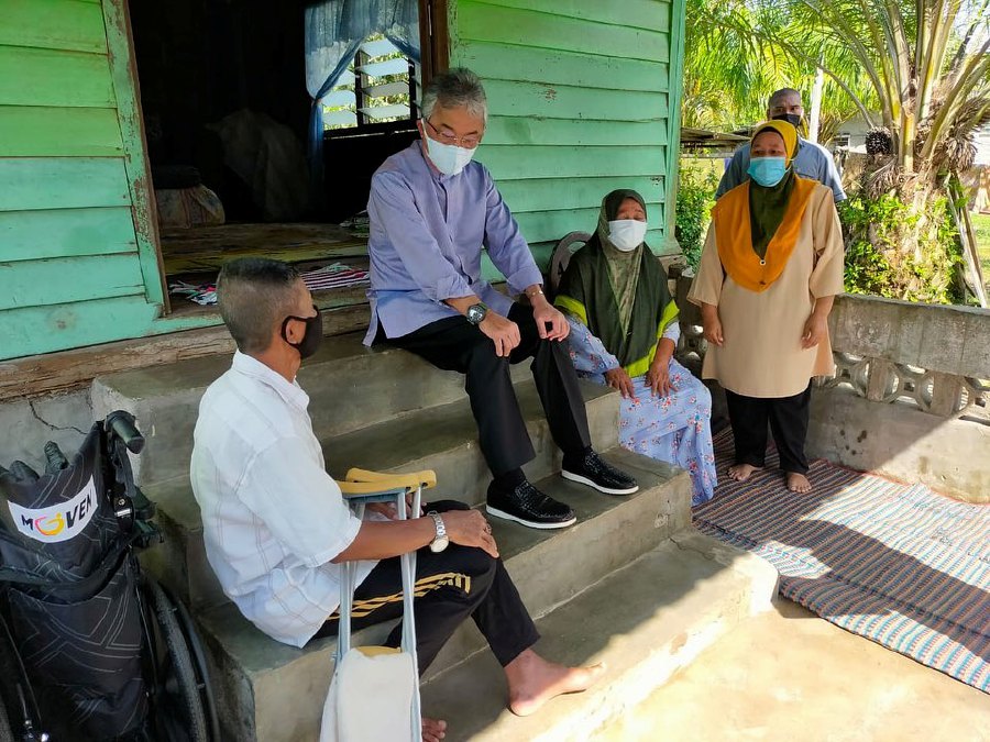 Yang di-Pertuan Agong Al-Sultan Abdullah Ri’ayatuddin Al-Mustafa Billah Shah speaking to a family during the visit and handing over of contributions to needy families in Kampung Gading, Rompin, in Pahang. - Pic credit Facebook @ IstanaNegaraOfficial.    