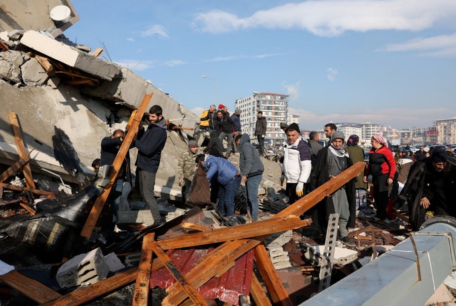 People look amid rubble as the search for survivors continues following an earthquake in Hatay, Turkey. - REUTERS PIC