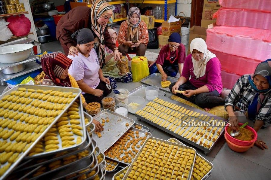 KUALA LUMPUR, March 19 — Cookie distributor Windana Bakri (centre) and her workers are busy preparing Eid al-Fitr cookies to fulfill orders at Jalan Raja Mahmud, Kampung Baru. -BERNAMA PIC 
