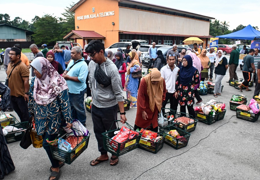 Shoppers waiting in lines to pay for their goods during the Mobile Rahmah Sales in Hulu Terengganu. - BERNAMA PIC