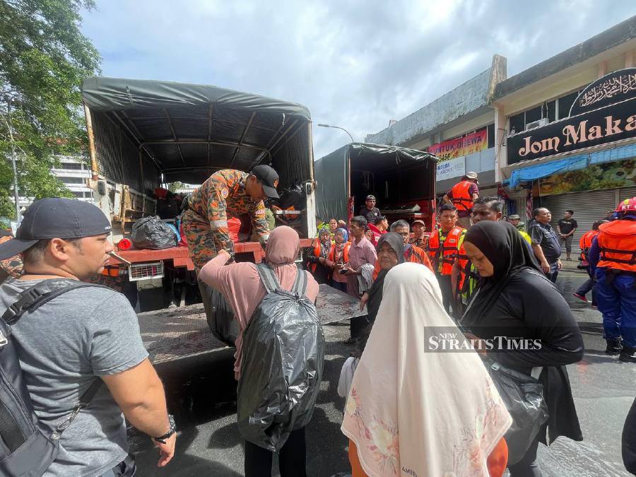 Firemen help evacuate residents of Taman Kemang in Kota Tinggi following the floods. -NSTP/NUR AISYAH MAZALAN