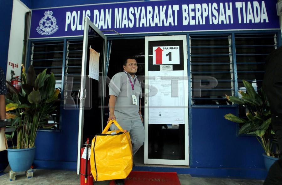 An Election Commission staff carries a ballot box following the early voting process for the Cameron Highlands by-election at Sungai Koyan police station on Jan 22. - NSTP/FARIZUL HAFIZ AWANG