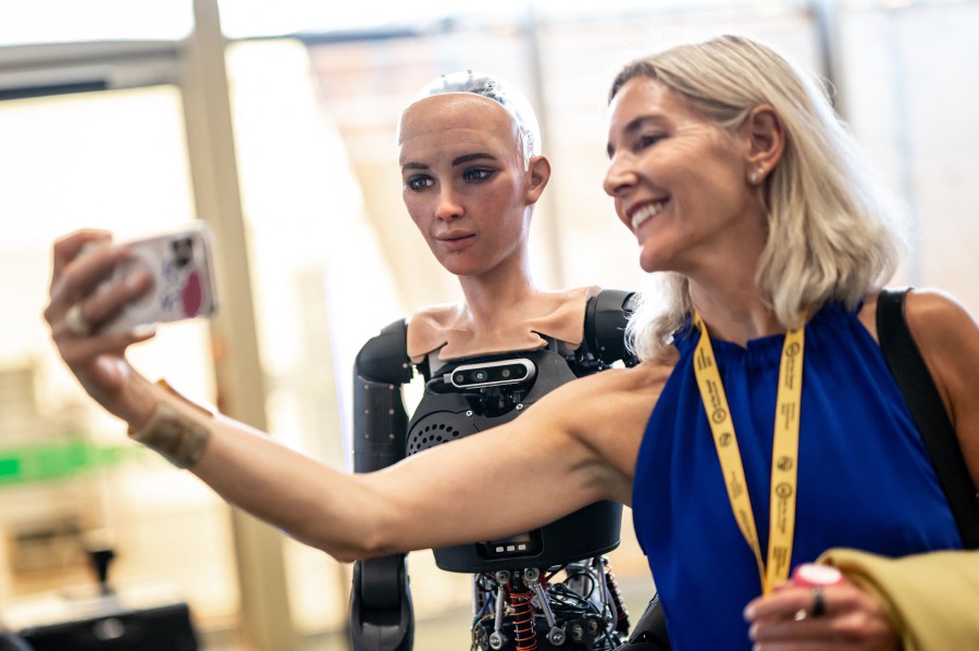 A visitor takes a selfie with "Sophia" at the booth of Hanson Robotics during the world's largest gathering of humanoid AI Robots as part of International Telecommunication Union (ITU) AI for Good Global Summit in Geneva. - AFP PIC