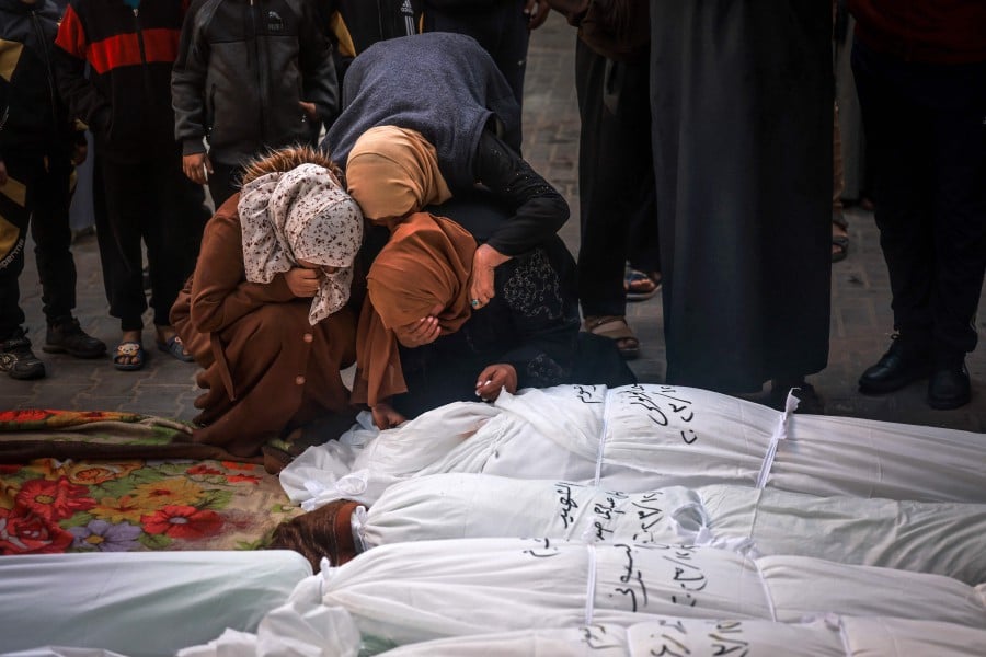 People mourn over the shrouded bodies of loved ones killed during Israeli bombardment at Al-Najar hospital in Rafah on the southern Gaza Strip. - AFP PIC