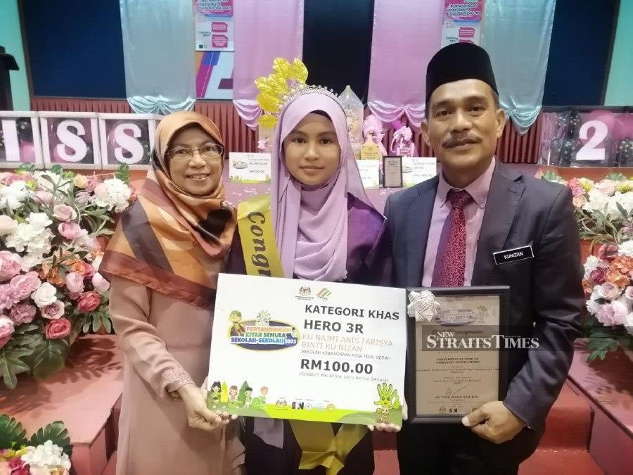 Twelve year-old Ku Najmi Farisya Kunizan (centre) from SK Pida 3 receives the state-level School Recycling Competition (Perkiss) Hero Award for her commitment in raising awareness about environmental sustainability at Kedah Education Department Complex. - NSTP/AHMAD MUKHSEIN MUKHTAR