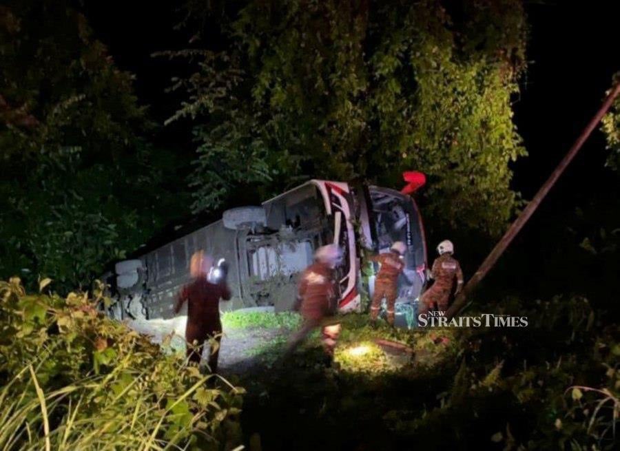 Firemen on the scene after an express bus skidded and plunged into a ravine at Batu 9, Jalan Silam. - Pic courtesy of Fire and Rescue Dept. 