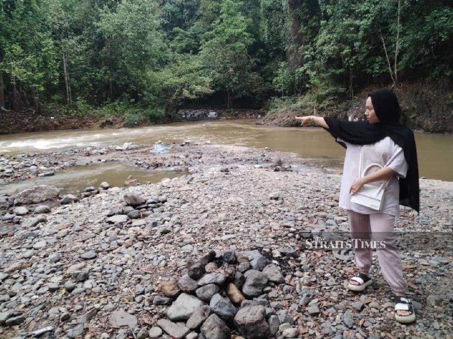 Siti Alia Aisha Mohd Afandi pointing a the location of the water surge at Lata Changkah in Hulu Seladang.-NSTP/Nurul Fatihah Sulaini