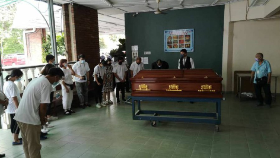 Family members of the late retired Senior Assistant Commissioner 1 Datuk Leong Chee Woh paying their last respects as his body lays in a coffin at the Gui Yuan Crematorium in Section 51 Kampung Tunku, Petaling Jaya, Selangor. - Pic courtesy of Datuk Leong Chee Woh's family