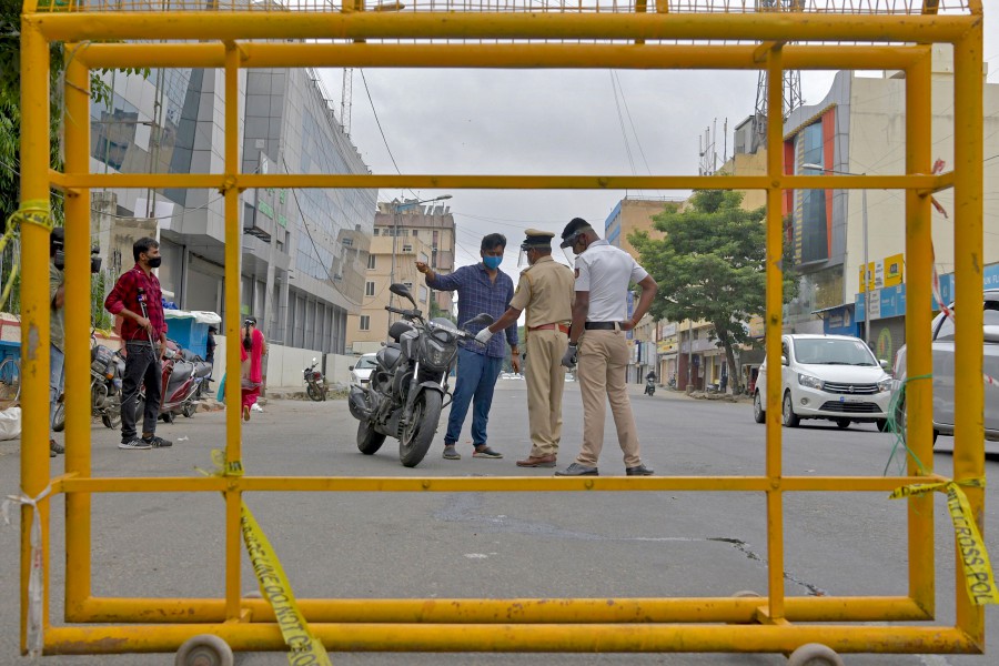 Policemen stop a motorist at a check post during a week-long lockdown to contain the surge of COVID-19 coronavirus cases, in Bangalore on July 15. - AFP pic