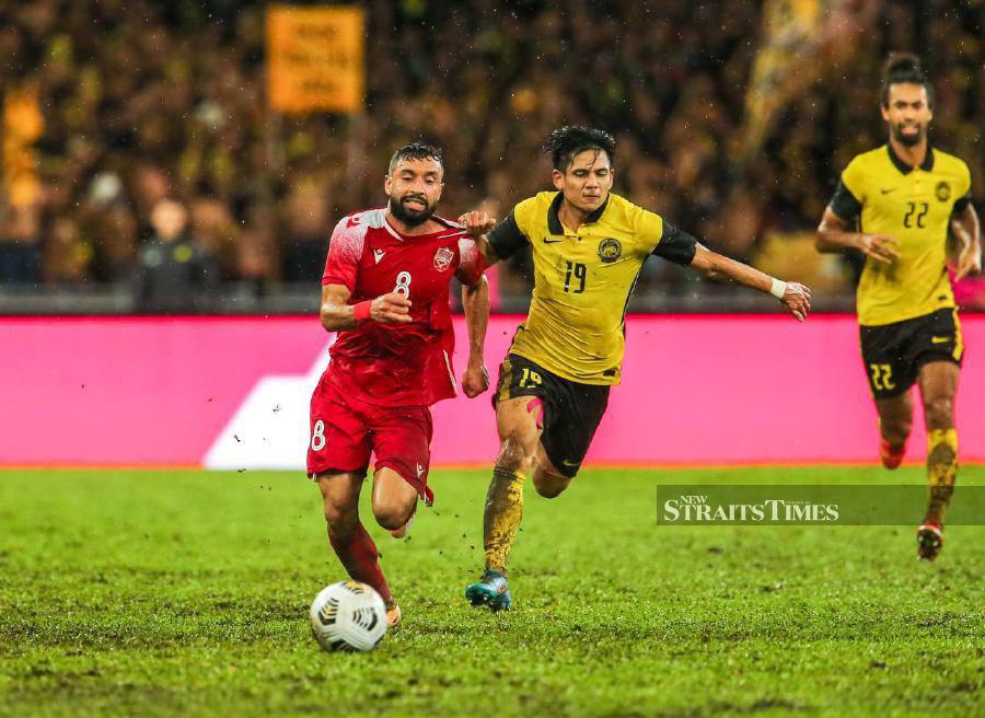 Malaysia’s Akhyar Rashid tussles for the ball with a Bahrainian player during the match at Bukit Jalil National Stadium. - NSTPASWADI ALIAS.