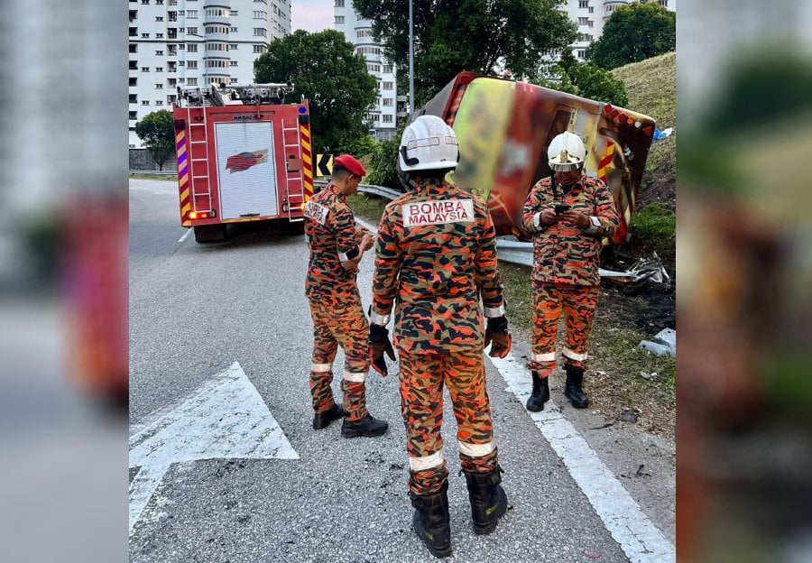 Firemen at the scene of the accident where an express bus skidded and crashed into a road divider near the Jalan Duta toll early today morning. - PIC COURTESY: Fire and Rescue Department