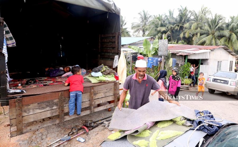 A family of eight had to spend the night inside a three-tonne lorry yesterday when their house in Kampung Belimbing Dalam, here, was flooded in about 60cm of flood water. (NSTP/RASUL AZLI SAMAD)