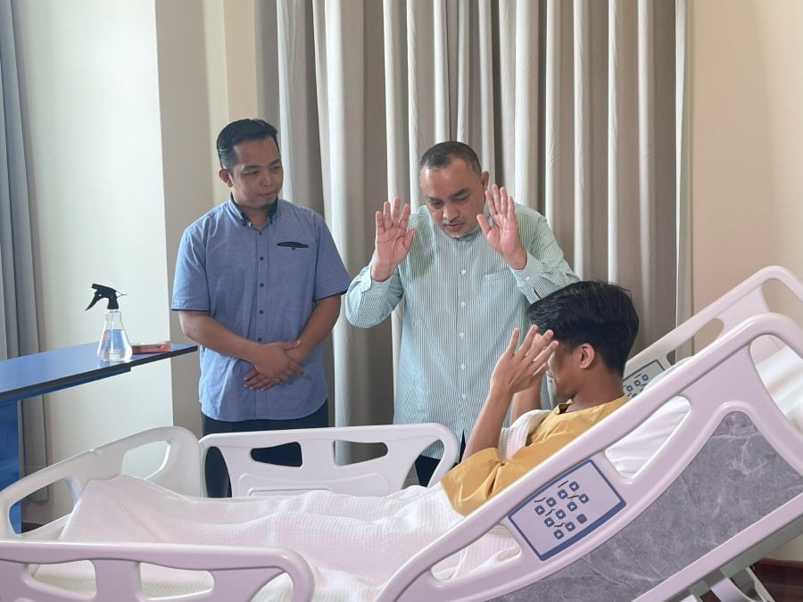 A religious officer and counsellor assisting a patient to perform prayers during hospitalisation.
