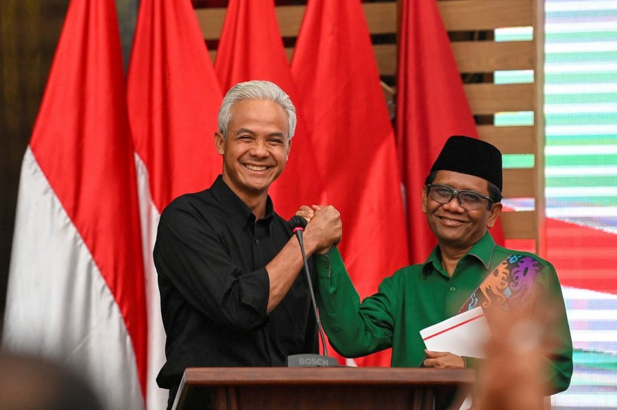  Ganjar Pranowo, presidential candidate of the ruling Indonesian Democratic Party-Struggle (PDI-P), poses for photographs with his running mate, Mahfud MD, during their declaration in Jakarta, Indonesia, October 18, 2023. - REUTERS PIC