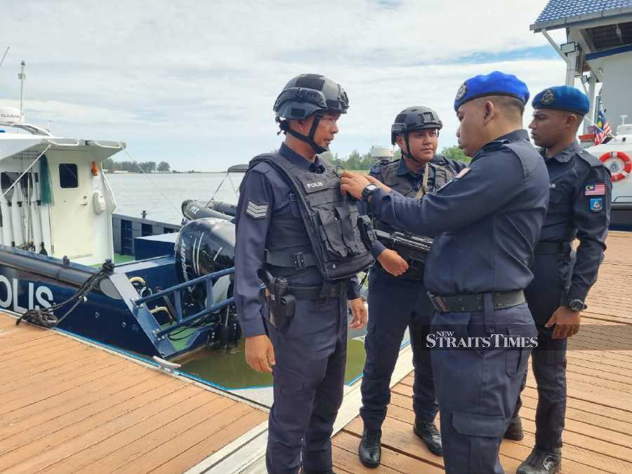 Third Region Pengkalan Kubor marine operation base commanding officer, Assistant Superintendent Akil Abd Rauf checks his officer's bulletproof vests in Tumpat today. NSTP/SHARIFAH MAHSINAH ABDULLAH