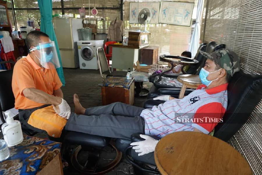 Blind masseure Sartaim Torimo, 61, adapting to new normal at a reflexology centre at Bukit Padang here. - Pic by NSTP/OLIVIA MIWIL