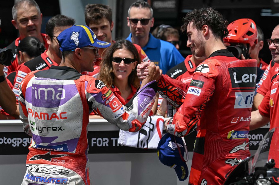 Ducati Lenovo Team's Italian rider Francesco Bagnaia (R) celebrates securing pole position with second place Prima Pramac's Spanish rider Jorge Martin (L) after the qualifying session of the MotoGP Malaysian Grand Prix at the Sepang International Circuit in Sepang. - AFP PIC