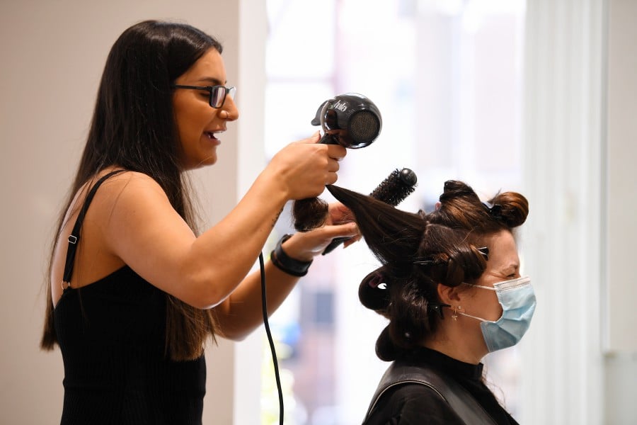  Hairdresser Caroline Shamoon (L) of Joey Scandizzo Salon works on a clients hair in Melbourne, Victoria, Australia. - EPA PIC
