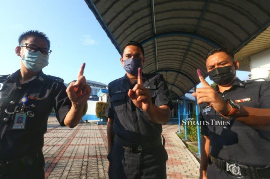  Police officers show their index finger after casting their ballots at the Melaka contingent police headquarters. - NSTP/SYAFEEQ AHMAD