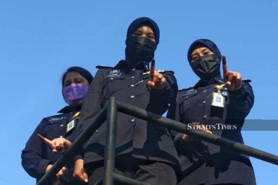 Some of the policewomen gesture after casting their ballots at the Melaka contingent police headquarters. - NSTP/SYAFEEQ AHMAD