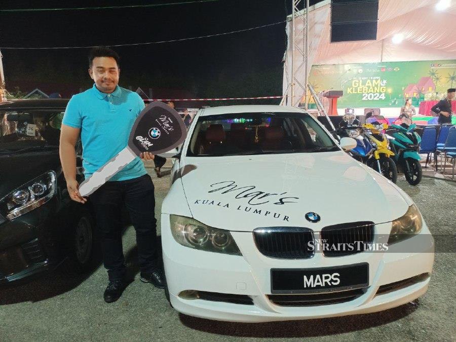 Auxiliary police officer Mohamad Helmi Mohammad, 32, won the grand prize of a BMW 320i at the Glam Bazaar Ramadan Klebang opening ceremony lucky draw here last night. - NSTP/ NAZRI ABU BAKAR