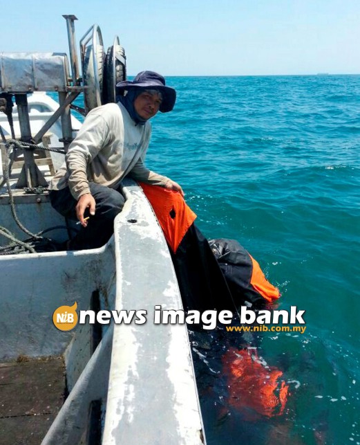 12 March 2014: A fisherman shows what is believed as an aeroplane’s safety rubber raft which was found about 10 nautical miles off Port Dickson at noon. Pix by Rozainah Abdul Rahim