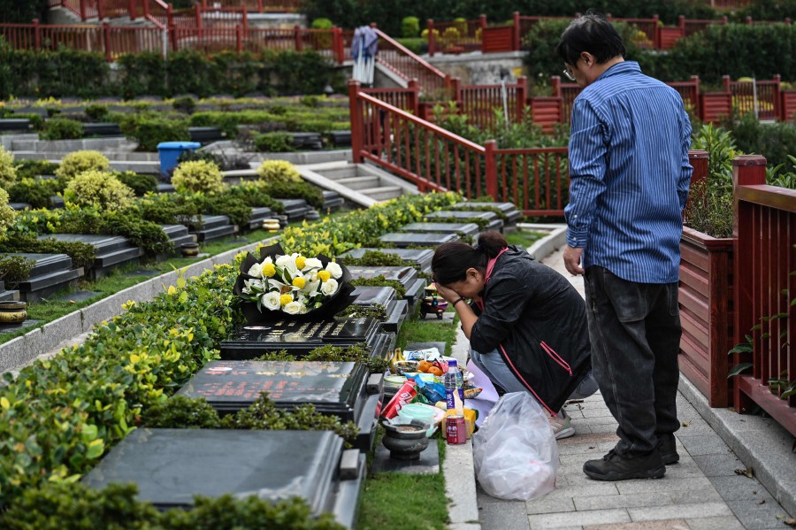 Seakoo Wu and his wife visiting the grave of their son Wu Xuanmo, at a cemetery in China's eastern Zhejiang province.- AFP PIC