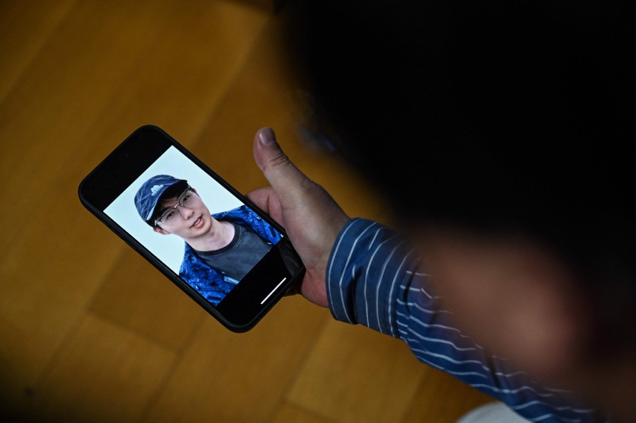 Seakoo Wu watching a video created with artificial intelligence showing the face and voice of his son, who died last year aged 22 while attending Exeter University in Britain, in China's eastern Zhejiang province.- AFP PIC