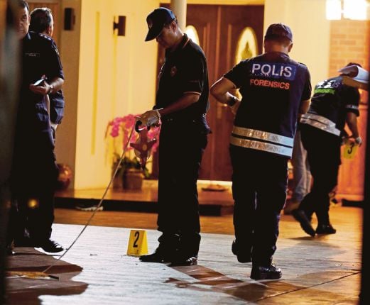 The police forensic team conducting their investigations in front of Penang Chief Minister Lim Guan Eng after a ‘molotov cocktail’ was thrown into the parking area of his residence in Jalan Pinhorn, George Town last night