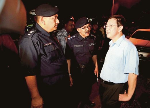 Penang Police Chief, Datuk Abdul Rahim Hanafi (centre), Chief Minister Lim Guan Eng (right) and Northeast district police chief ACP Mior Faridalatrash Wahid (left) discussing something after inspecting the place where the ‘molotov cocktail’ was thrown at his residence in Jalan Pinhorn