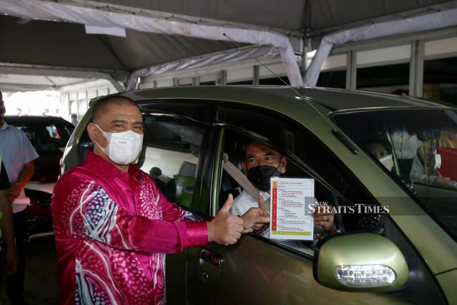 Perak Menteri Besar, Datuk Saarani Mohamad (left) with a recipient of Covid-19 vaccine gesture at the Indera Mulia Stadium vaccine delivery centre (PPV). -  NSTP/SHARUL HAFIZ ZAM